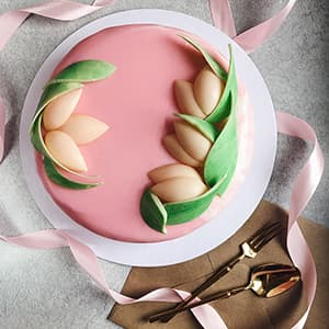 Cake with pink mirror glaze and edible chocolate tulips