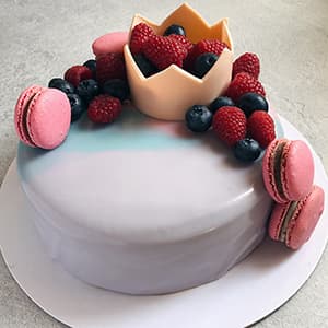 Chocolate crown, fruits and macarons on a cake