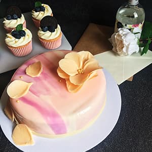 Cupcakes and mousse cake with orange chocolate flower