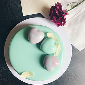 Turquoise mousse hearts on a cake